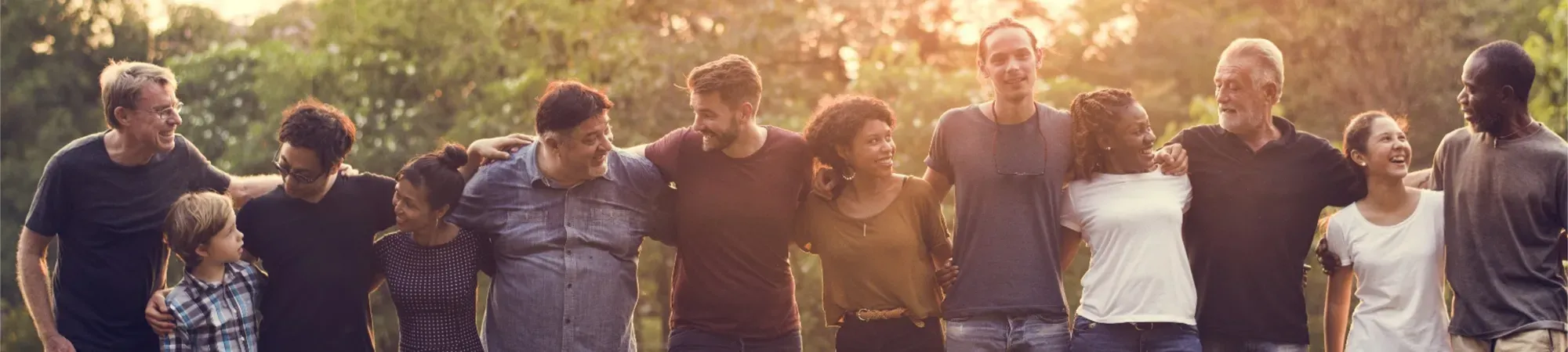 Diverse group of people linking arms and smiling