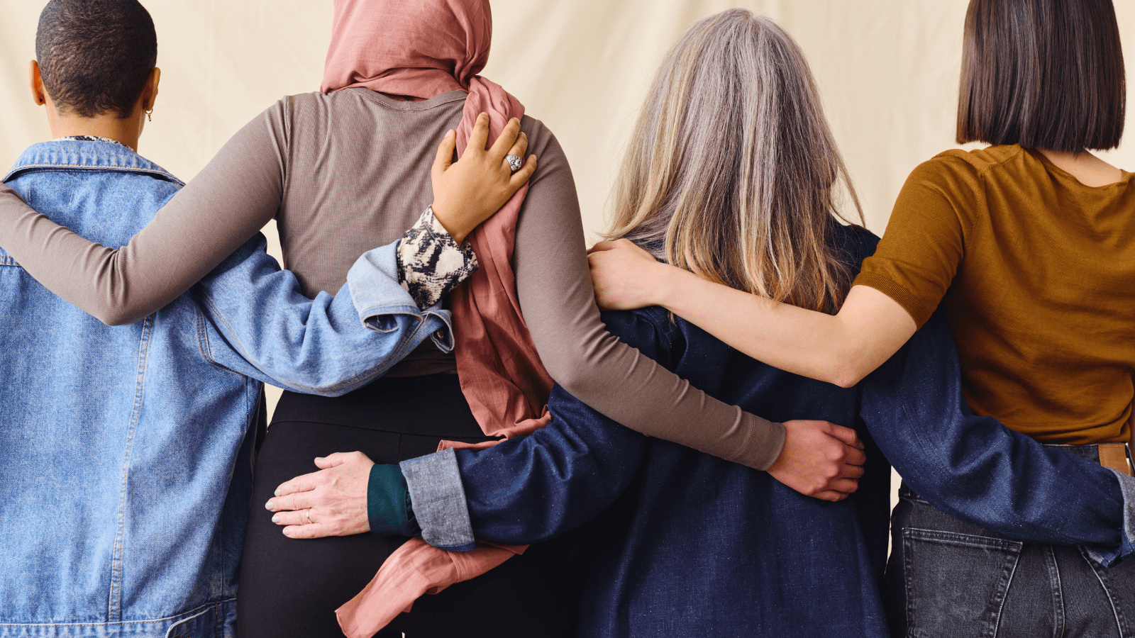 A diverse group of women linking arms