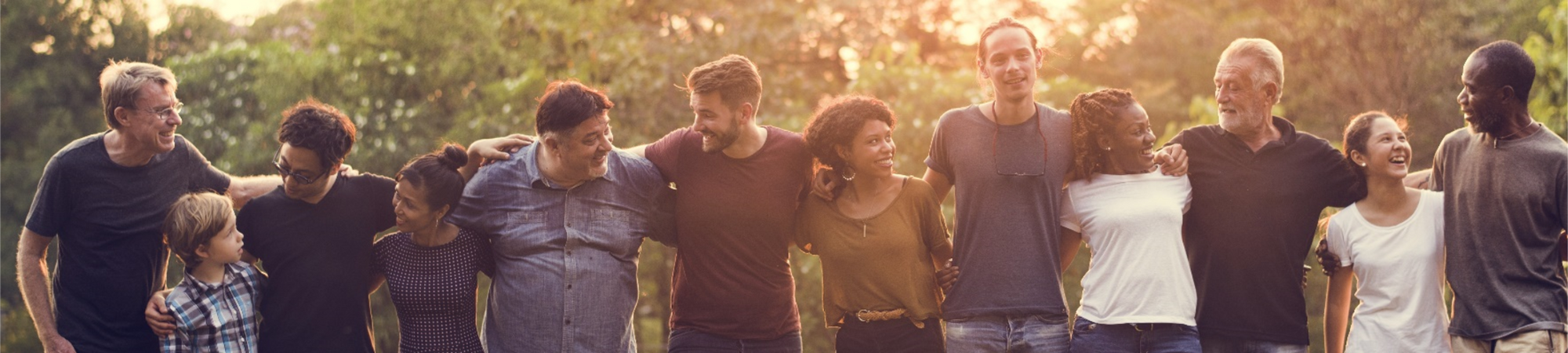 A diverse group of people linking arms and smiling